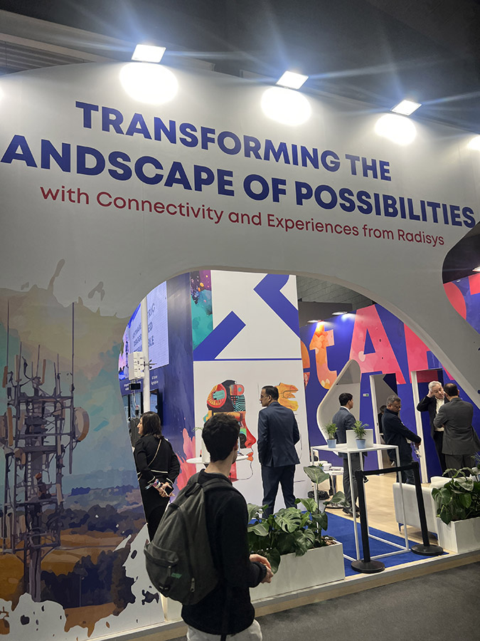 A wide shot of the Radisys booth with the slogan 'TRANSFORMING THE LANDSCAPE OF POSSIBILITIES' displayed prominently.