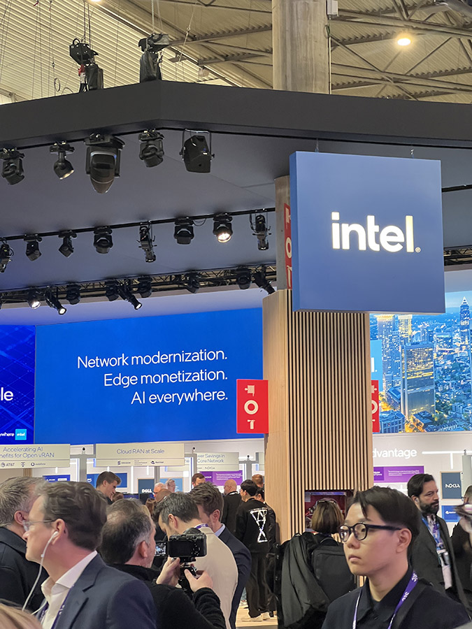 A shot of the Intel exhibit with a focus on the sign reading 'intel.' above a busy crowd.