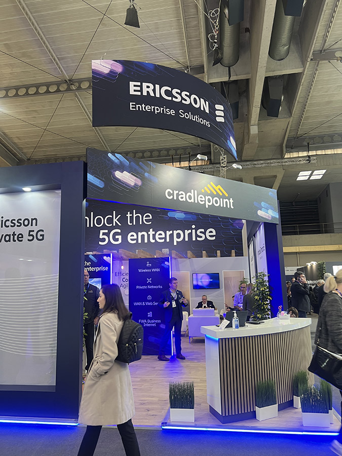 The Ericsson booth showcasing 'Unlock the 5G enterprise' with visitors and staff present.