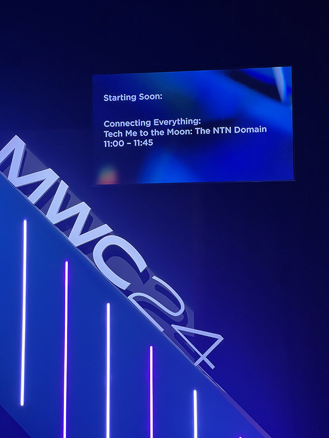 A screen announcing an upcoming event 'Connecting Everything: Tech Me to the Moon: The NTN Domain' at MWC24.