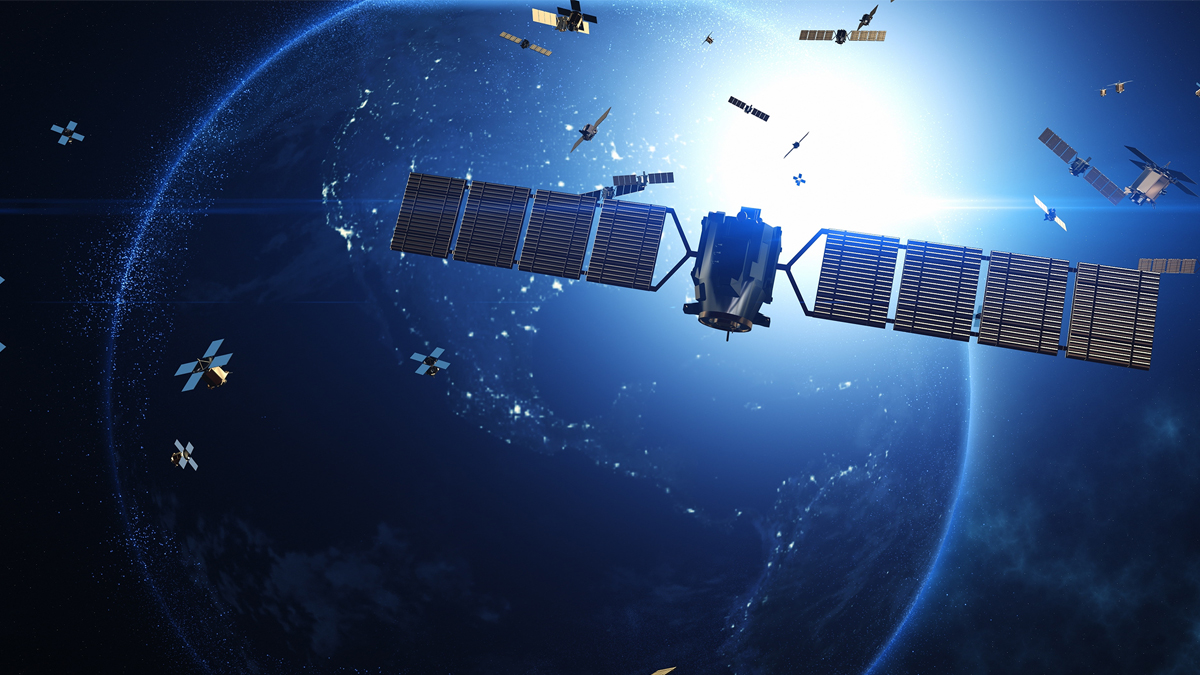 A large satellite with solar panels orbits the Earth, surrounded by numerous smaller satellites, all illuminated by the sun.