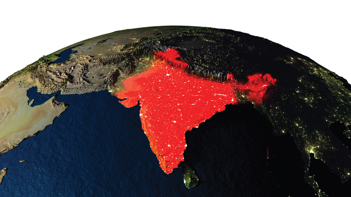 Satellite view of Earth at night with the nation of India highlighted in a glowing red.
