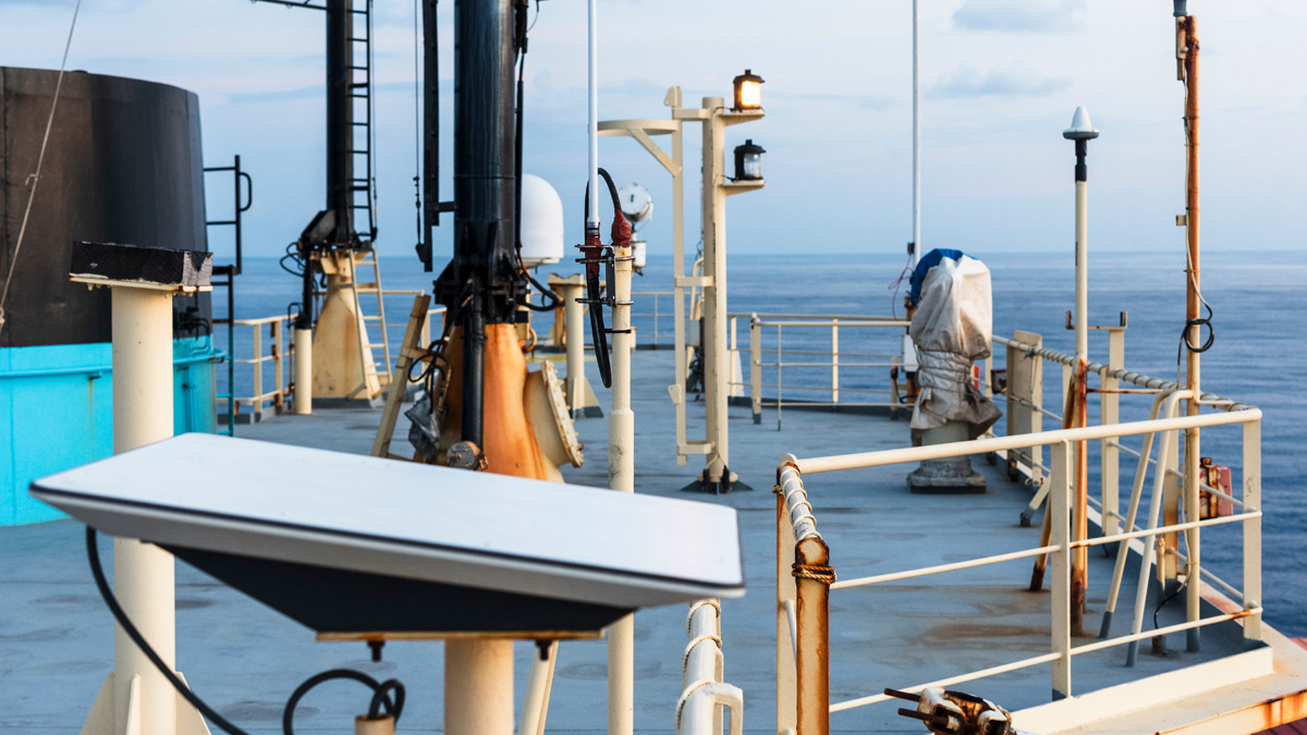 Retractable T-top and marine antenna on a ship's deck with ocean view.