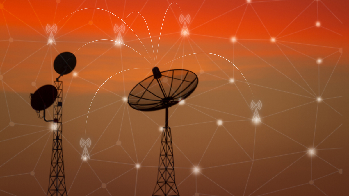 Silhouette of communication towers and satellite dishes with an overlay of network connections against an orange sky.