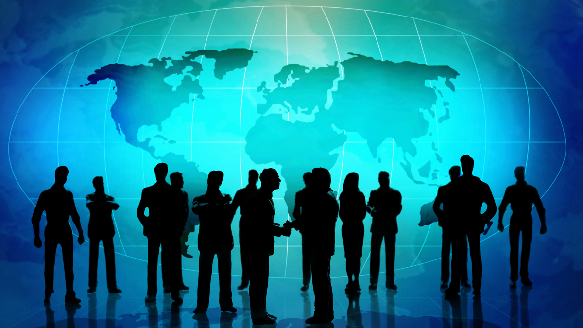 Silhouettes of business professionals networking in front of a large world map.