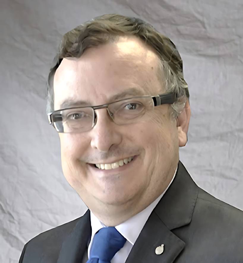 Gregg Burgess, wearing glasses and a suit, smiling.