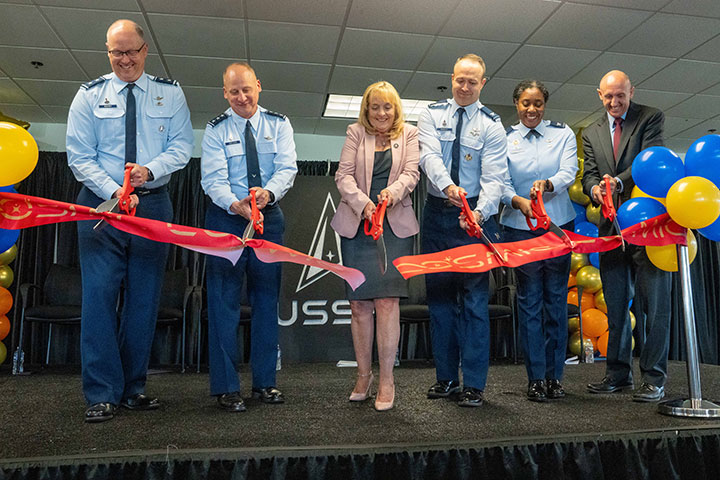 (Left to right) Maj. Gen. Steve Whitney of the Air Force for Space Acquisition and Integration, Lt. Gen. Michael Guetlein head of Space Systems Command, Joy White, Space Systems Command, executive director, Col. Richard Knisely, senior materiel leader for COMSO, Col. Janelle Jackson of the AFRL and John Forte, CEO and President of the Virginia Tech Applied Research Corporation lead the ribbon cutting for COSMIC, June 6, 2023, in Chantilla, Va.