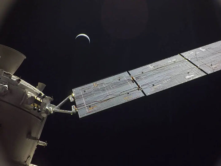 The Orion spacecraft for the Artemis I lunar return mission takes a photo of itself with the moon as a backdrop.