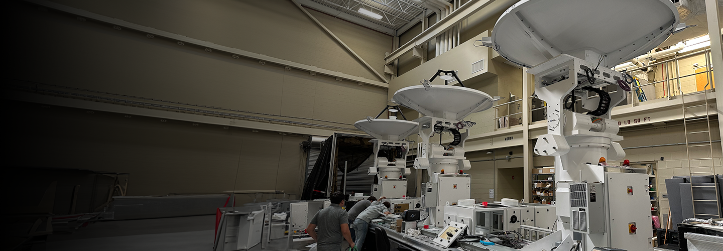 employees working on satellite dishes in workshop